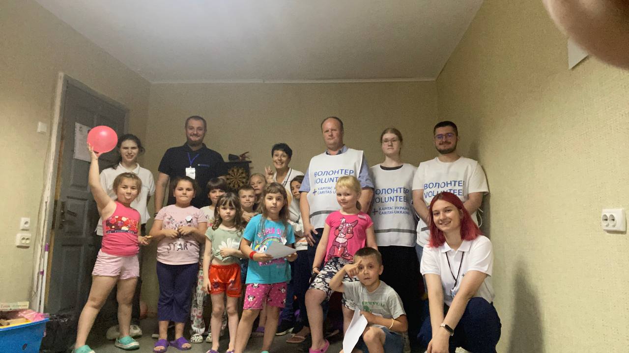 Діти внутрішньопереміщених осіб в шетлері з працівниками Карітасу