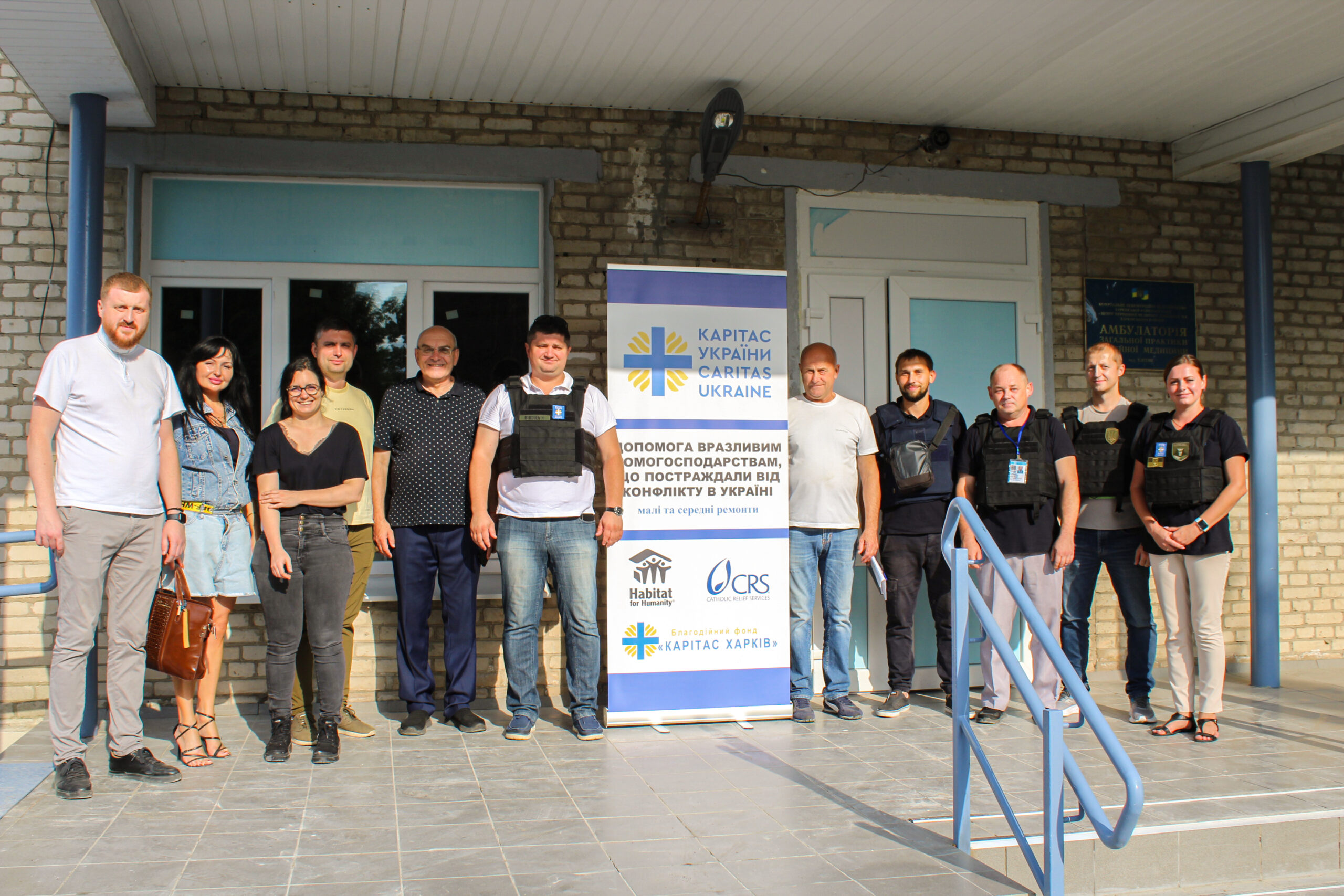 Команда проєкту "Habitat for humanity" з директором Карітасу Харків та донорами біля відновленої будівлі амбулаторії в сел. Елітне